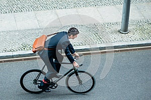 Young man wearing business suit while riding an utility bicycle