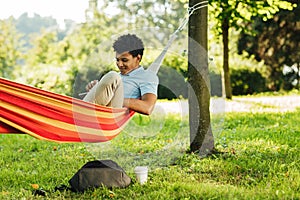 Young man wearing casuals resting on a hammock photo