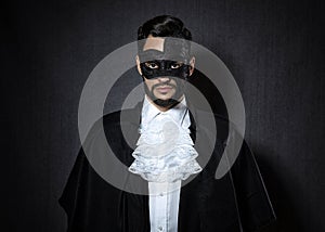 Young man wearing a dark mask, dressed in a Phantom of the Opera look