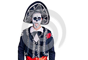 Young man wearing day of the dead costume over background sticking tongue out happy with funny expression