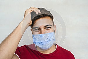 Young man wearing face mask portrait - Latin boy using protective facemask for preventing spread of corona virus