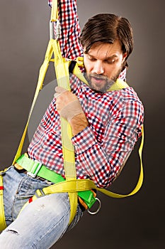 Young man wearing a fall protection harness and lanyard for wor