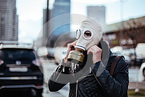 Young man wearing a gas mask on a city street