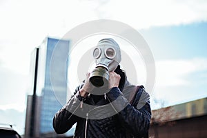 Young man wearing a gas mask on a city street