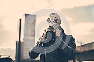 Young man wearing a gas mask on a city street