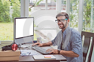 Young man wearing the glasses and working from home with computer