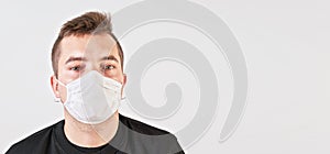 Young man wearing home made cotton face mouth nose virus mask. Studio portrait with space for text right side - can be used during