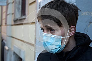young man wearing a medcal mask in outdoor during the covid-19 pandemic