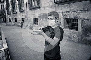 Young man wearing protective face mask video calling friends in the New Normal