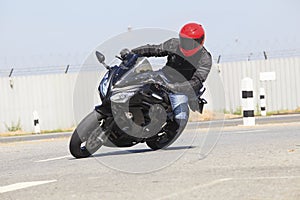 Young man wearing safety suit and red anti knock helmet riding