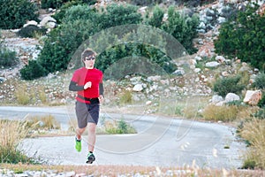 Young man wearing sunglasses on a morning jog in the countryside