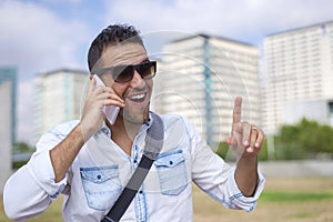 Young man wearing sunglasses while using mobile phone in the street