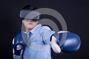 Young man wearing virtual reality goggles and boxing gloves