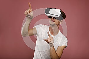 Young Man wearing virtual reality goggles over pink background. 3D virtual lifestyle concept