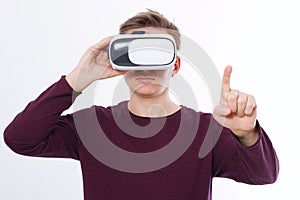 Young Man wearing virtual reality goggles and toch space by finger isolated on white background. VR concept and copy space.