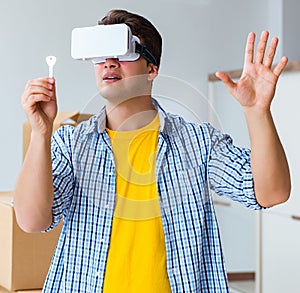 Young man wearing VR glasses moving in new apartment