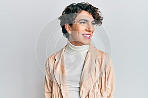 Young man wearing woman make up and woman clothes looking to side, relax profile pose with natural face and confident smile