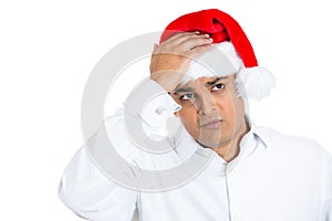 A young man wearing xmas hat expressing grief