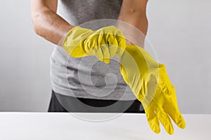 Young man wearing yellow rubber gloves. Ready to cleaning