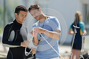 young man in wetsuit learning how to knot rope photo