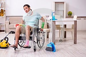 Young man in wheel-chair cleaning the house