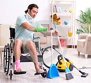 Young man in wheel-chair cleaning the house