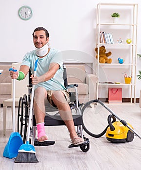 Young man in wheel-chair cleaning the house