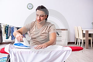 The young man in wheel-chair doing ironing at home