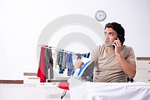 Young man in wheel-chair doing ironing at home