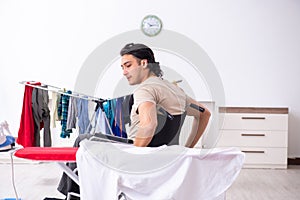 Young man in wheel-chair doing ironing at home