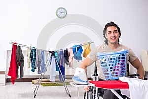 Young man in wheel-chair doing ironing at home