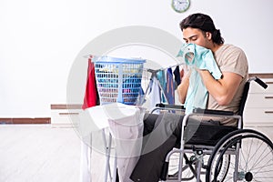 Young man in wheel-chair doing ironing at home