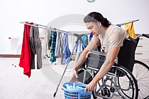 Young man in wheel-chair doing ironing at home