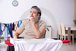 Young man in wheel-chair doing ironing at home