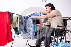 Young man in wheel-chair doing ironing at home