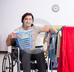 Young man in wheel-chair doing ironing at home