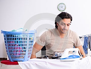 Young man in wheel-chair doing ironing at home