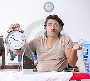 Young man in wheel-chair doing ironing at home