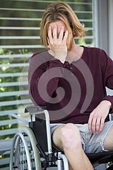 Young man in wheel chair looking desperate