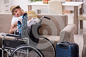 Young man in wheel-chair preparing for departure at home