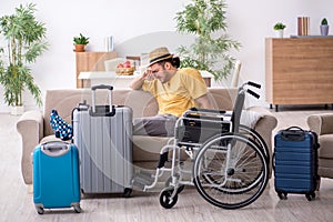 Young man in wheel-chair preparing for departure at home