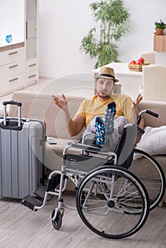 Young man in wheel-chair preparing for departure at home