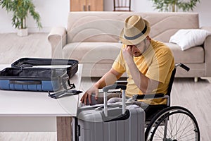 Young man in wheel-chair preparing for departure at home