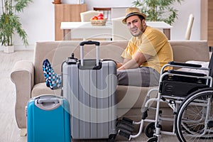 Young man in wheel-chair preparing for departure at home