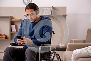 Young man in wheel-chair suffering at home