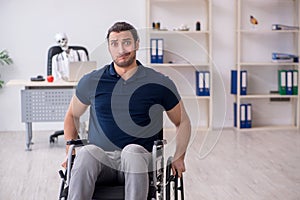 Young man in wheel-chair visiting dead doctor