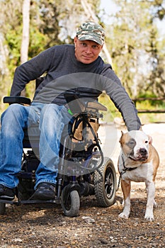 Young man in a wheelchair with his faithful dog. photo