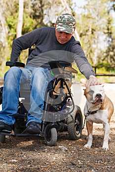 Young man in a wheelchair with his faithful dog .