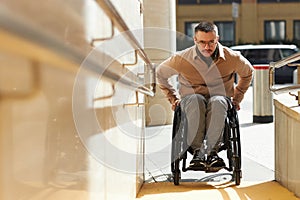 Man in wheelchair moving up the ramp