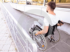 Young man in wheelchair on ramp outdoors